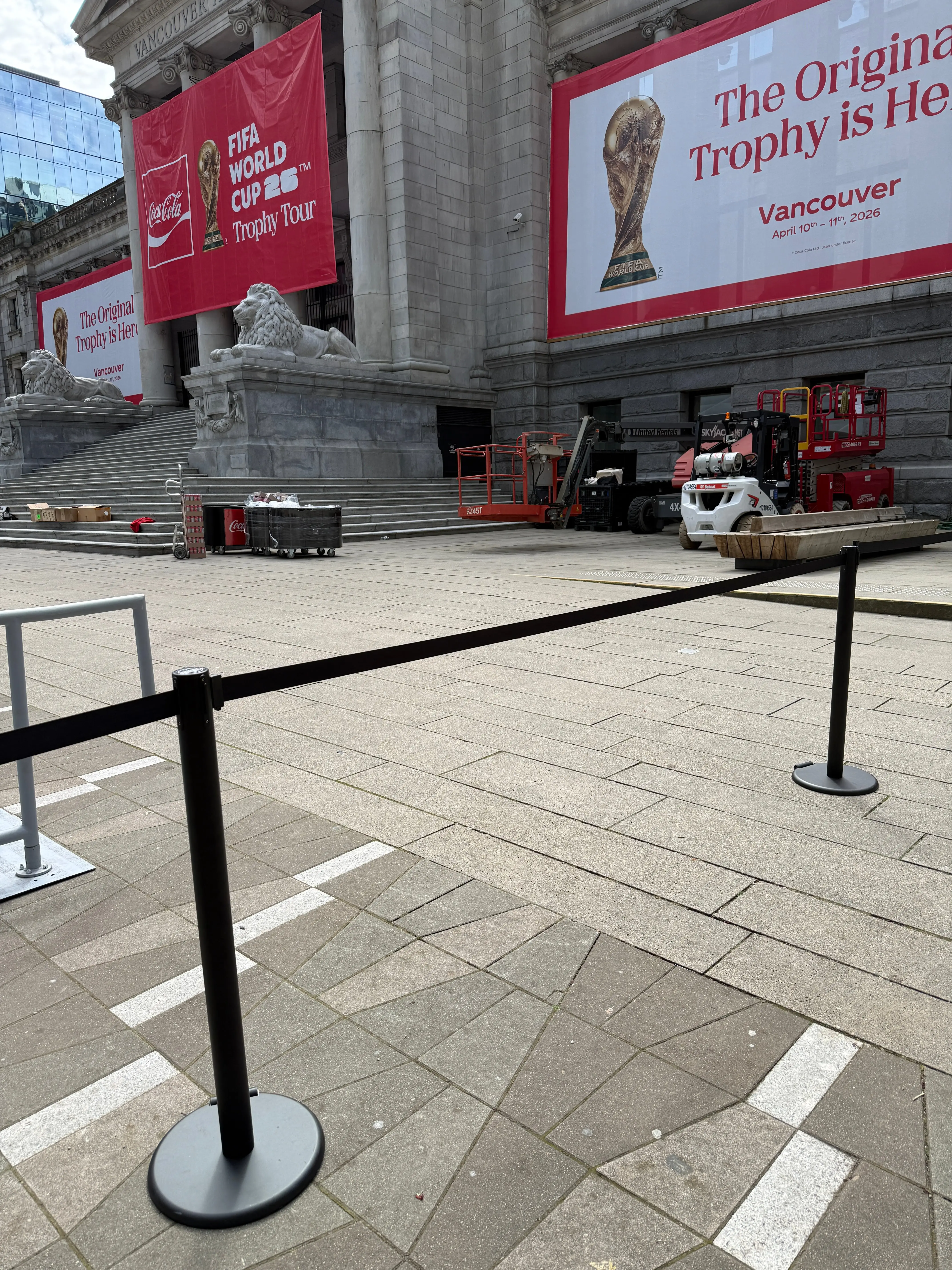 Black belt stanchions holding a line across a plaza