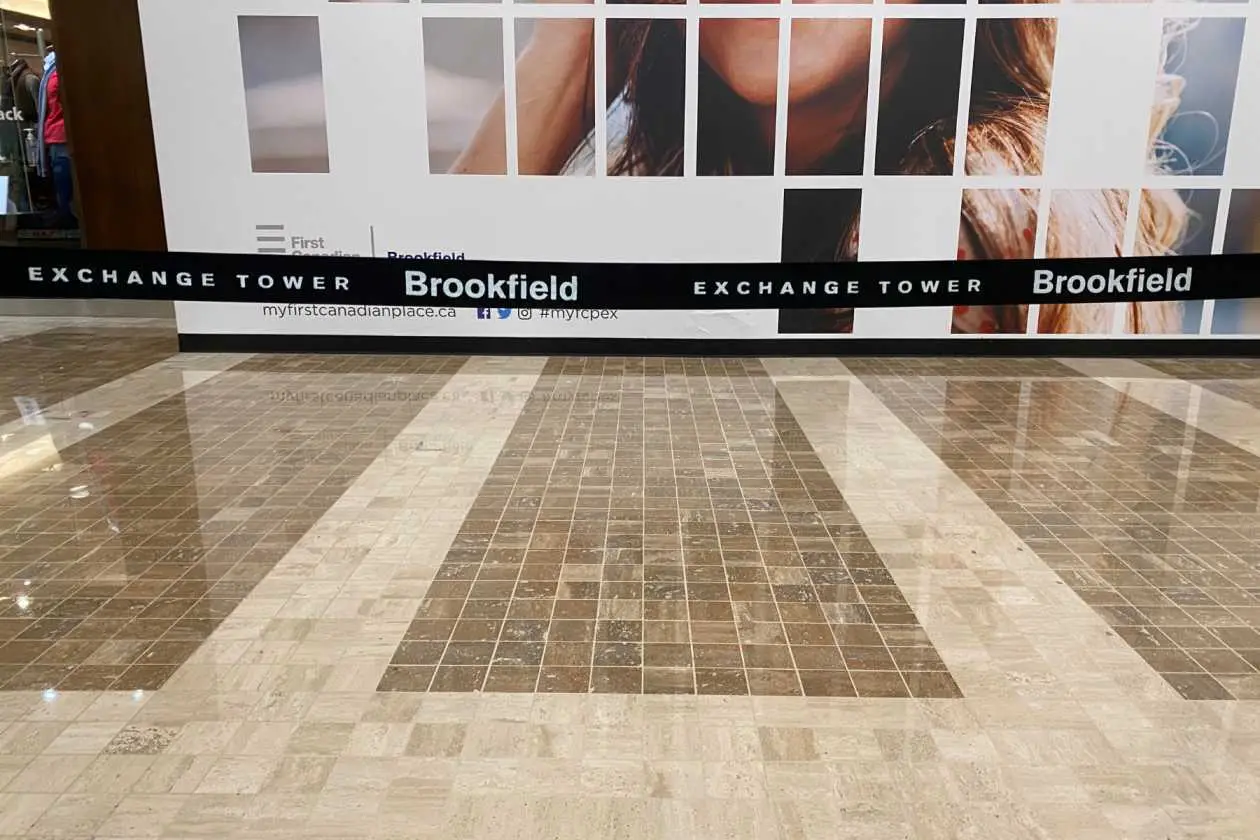 A belt stanchion line across a polished stone lobby floor