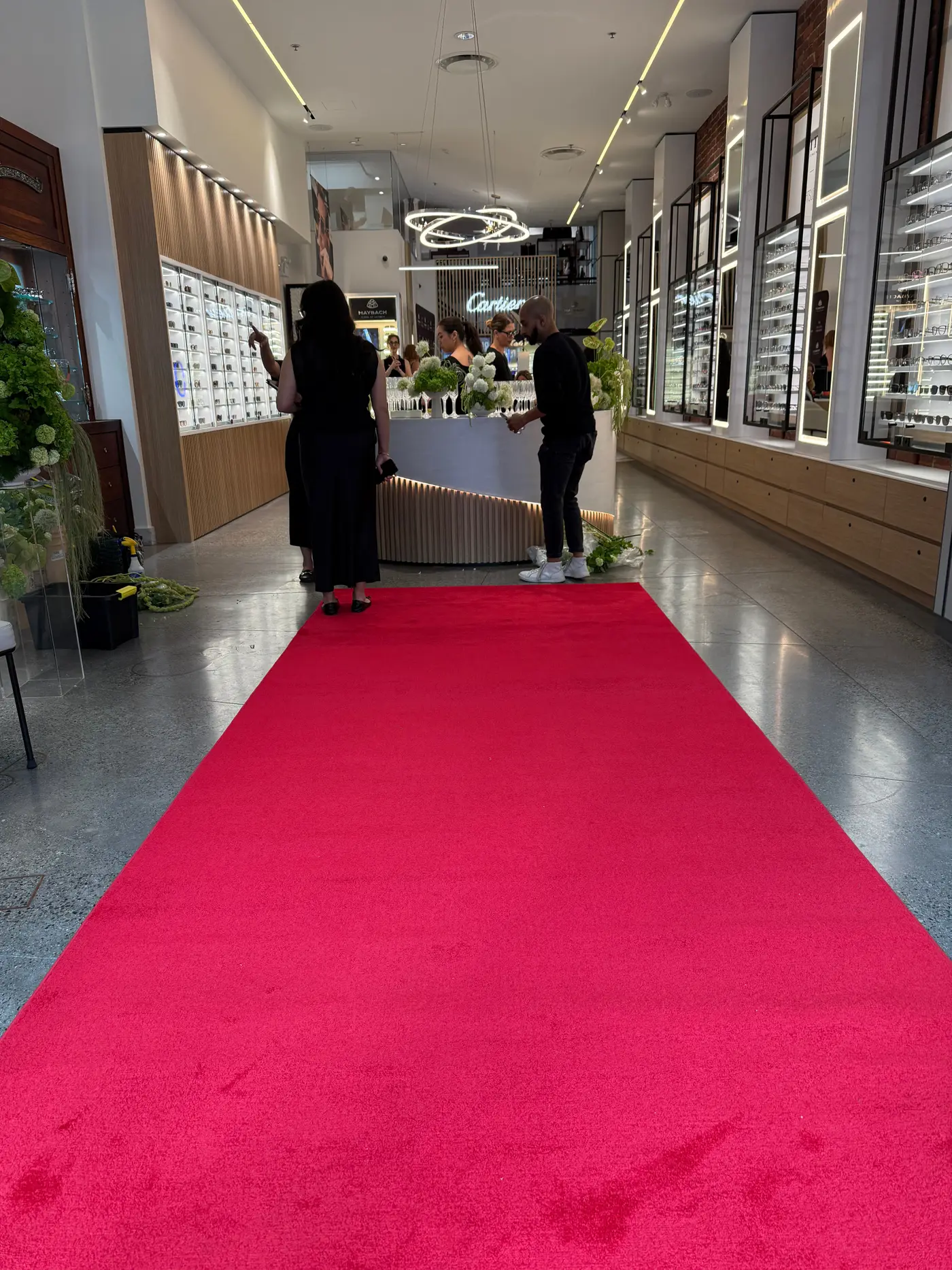 A red carpet runner down the length of a retail floor between display cases