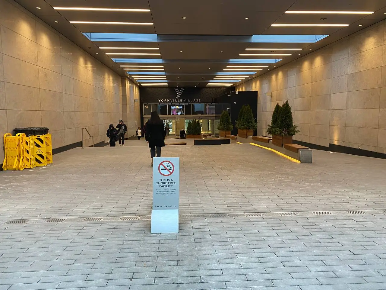 No smoking sign on a post in a covered public walkway