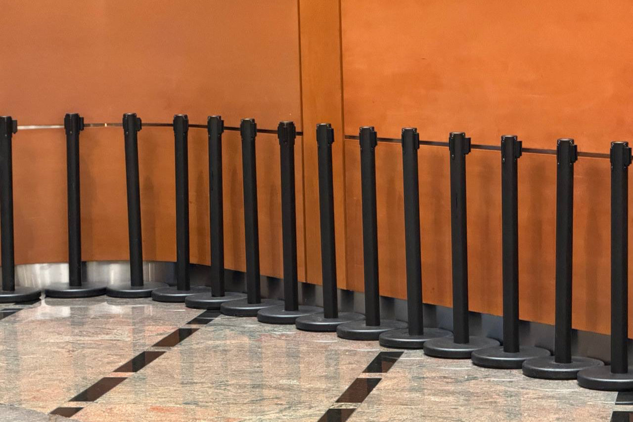 Row of black stanchions against an orange wall