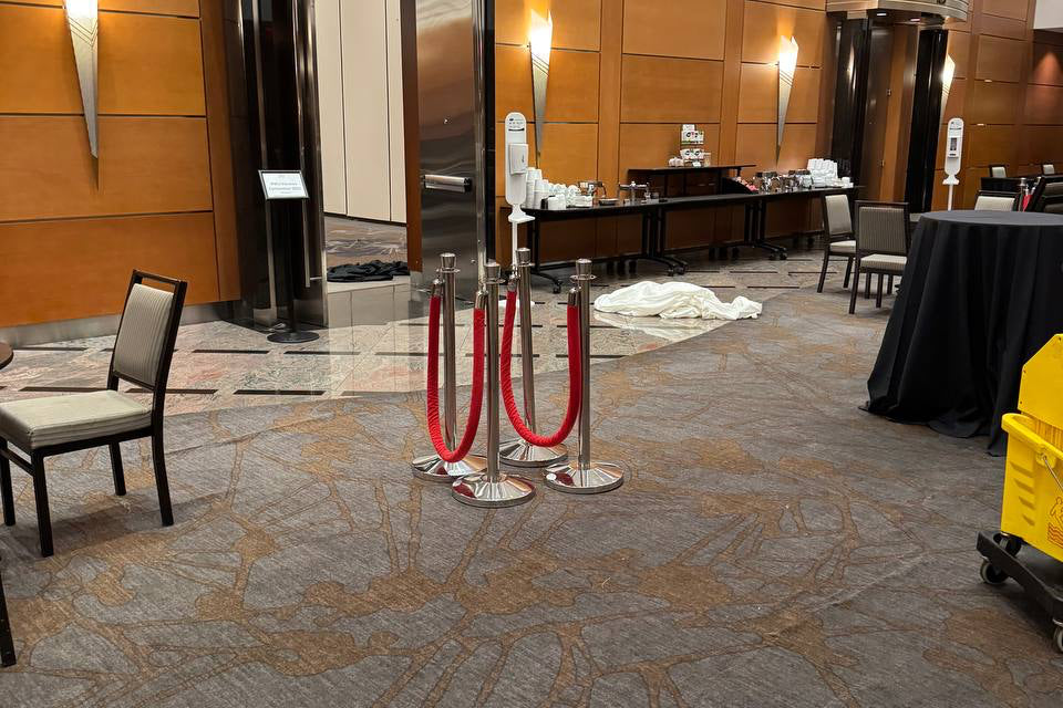 Conference room with red velvet rope barriers.