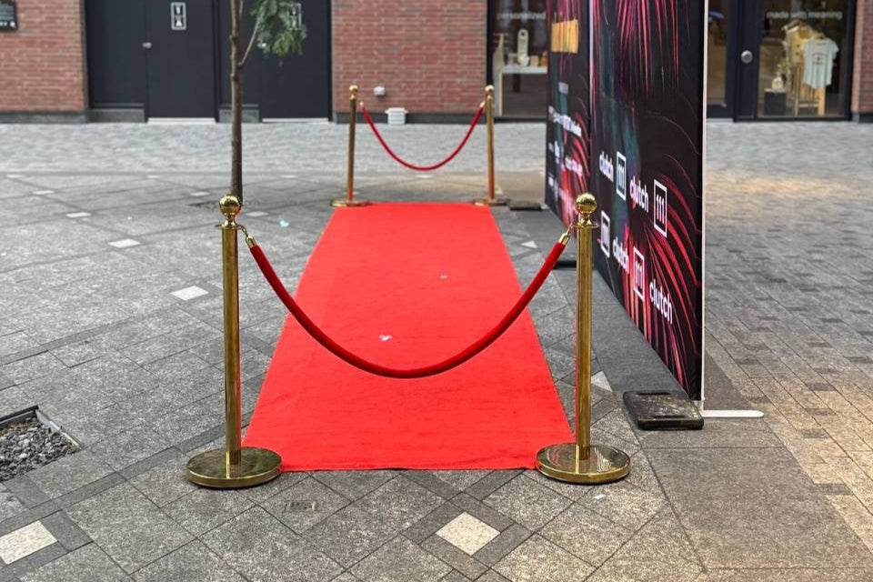 Red carpet with gold stanchions in an urban setting